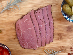 Pastrami halal de bœuf aux épices tranché sur planche en bois