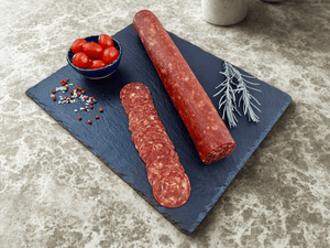 Saucisson sec halal pepperoni entier sur ardoise avec herbes