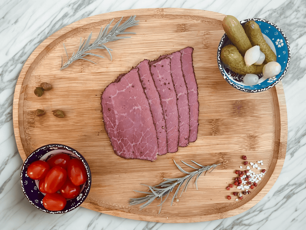 Pastrami halal de bœuf aux épices tranché sur planche en bois