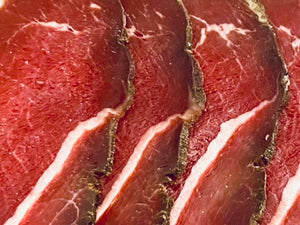 Gros plan sur des tranches de noix de bœuf fumée halal montrant la texture de la viande
